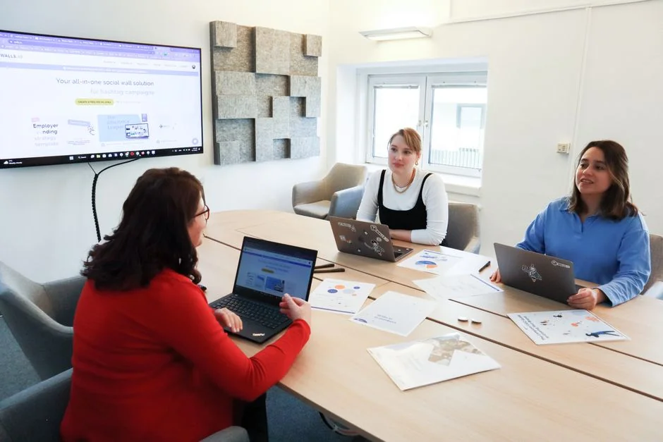 Business professional reviewing financial charts on a laptop in a contemporary office environment.