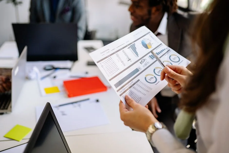 home-hero-bg Team working on marketing strategy using data charts and papers in an office meeting.